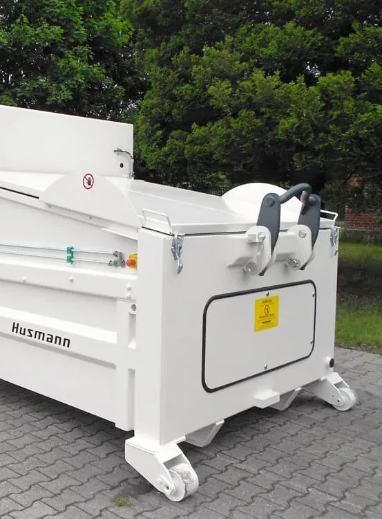 Compactor container with a loading chute on a yard
