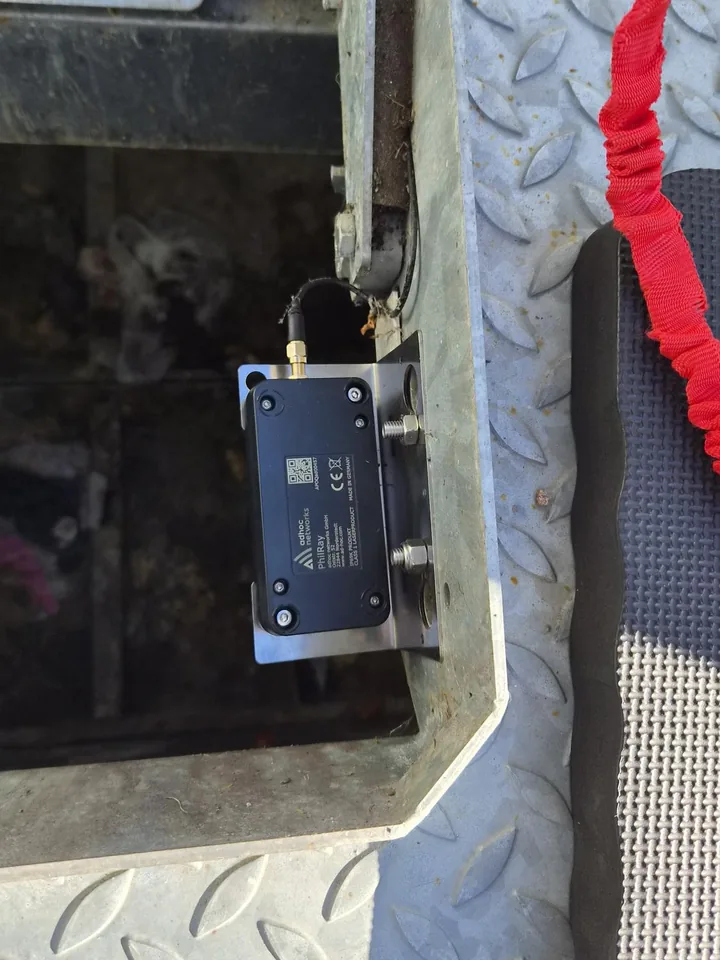 PhilRay-Sensor auf einem Halter an der Schnittstelle eines Unterflurbehälters, mit Antennenkabel